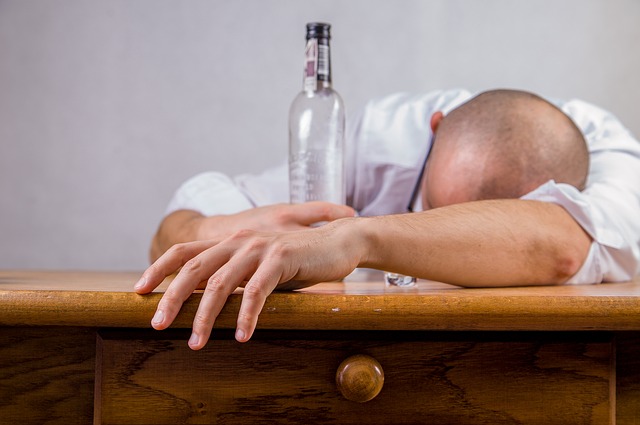 drunken man slumped over table
